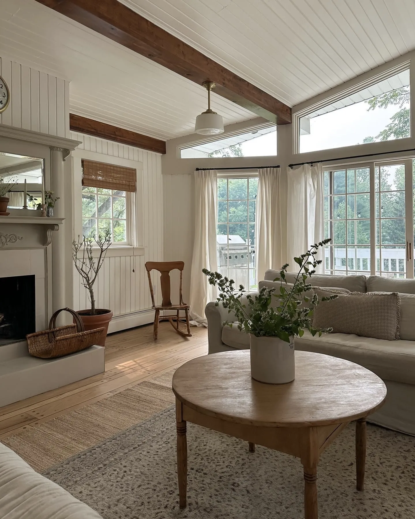 Modern living room with bamboo furniture, eco-friendly TV cabinet, floating shelves, black sofa, and minimalist farmhouse design for sustainable home decor.