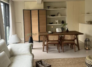 Modern living room with bamboo furniture, eco-friendly TV cabinet, floating shelves, black sofa, and minimalist farmhouse design for sustainable home decor.