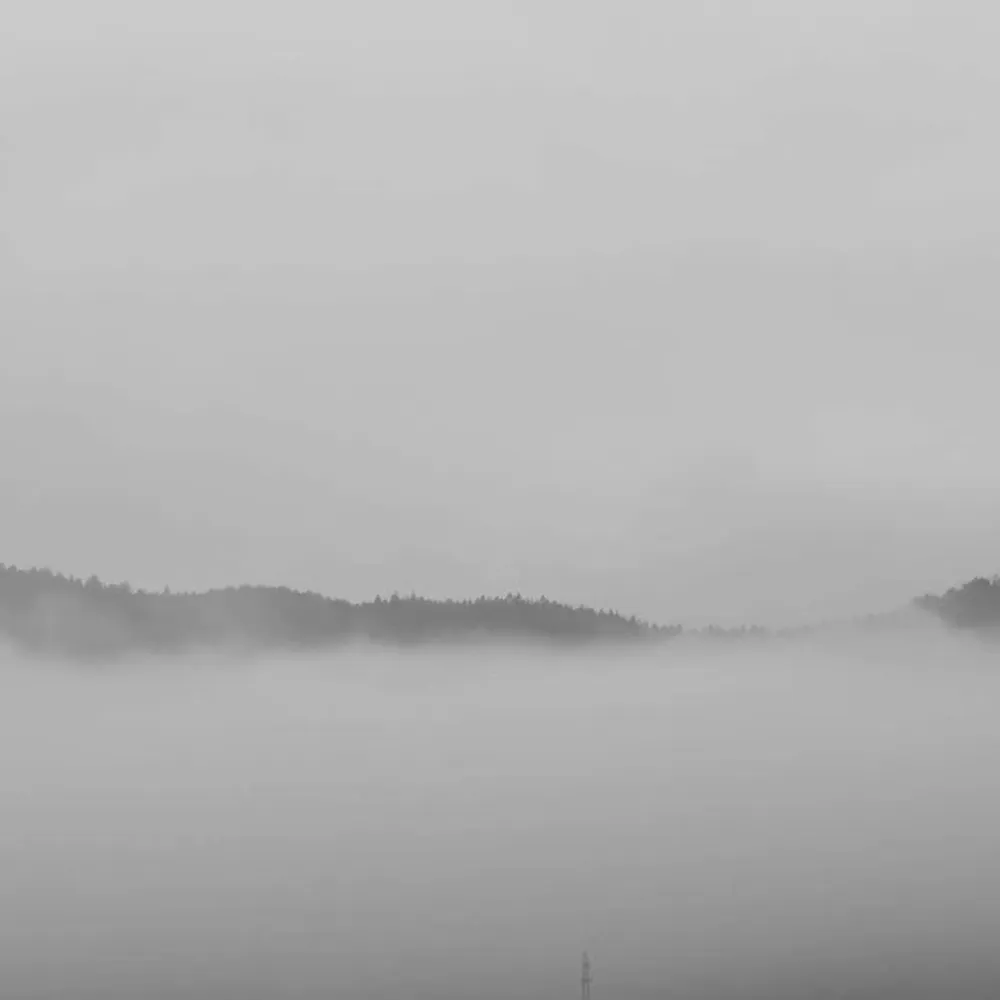 Majestic mountains emerging through a sea of clouds, symbolizing the timelessness and enduring vision behind our handcrafted bamboo furniture collections.